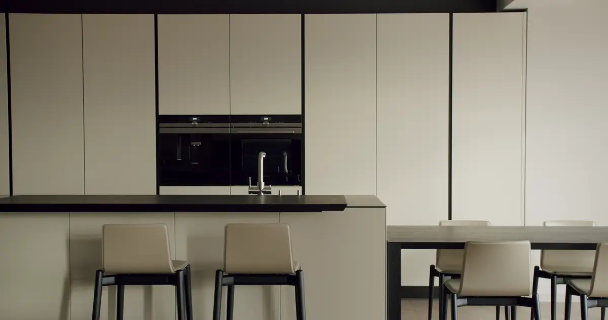 Kitchen with cream painted cabinets and black stools