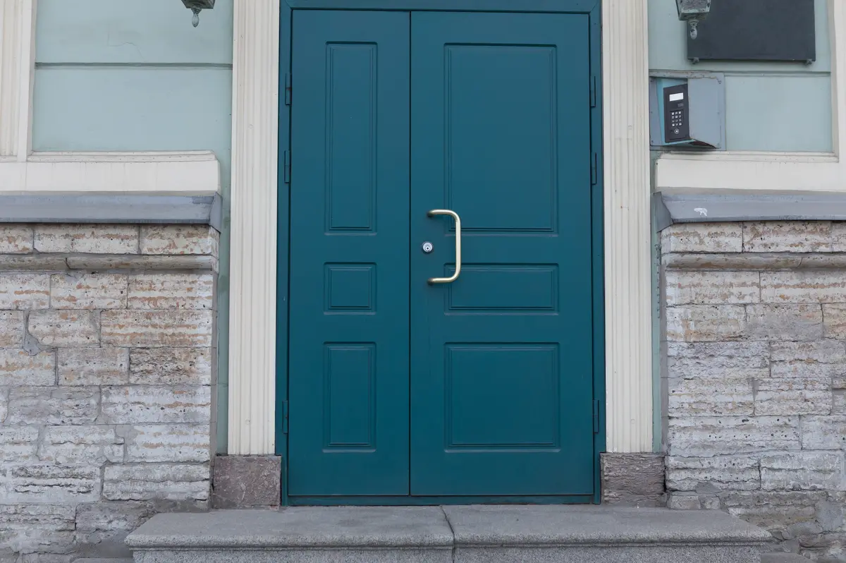Teal blue double entry doors framed in white