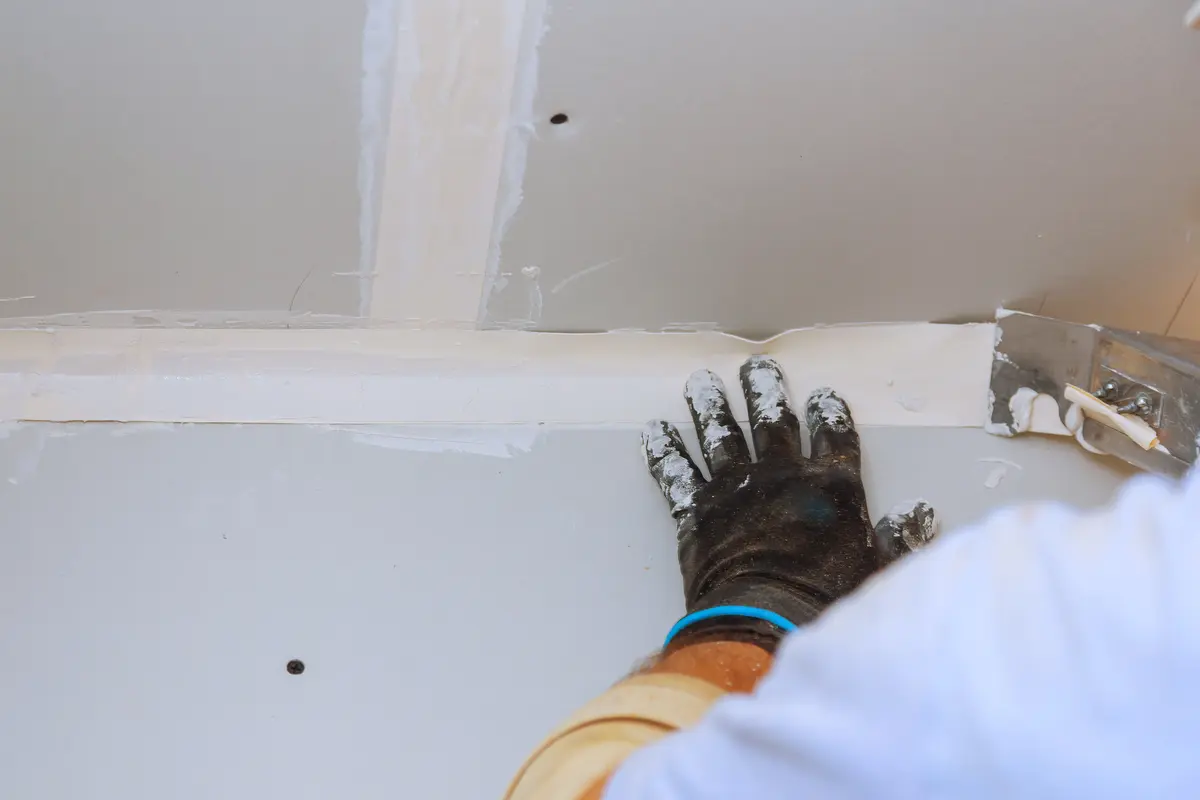 Taping knife finishing a drywall joint