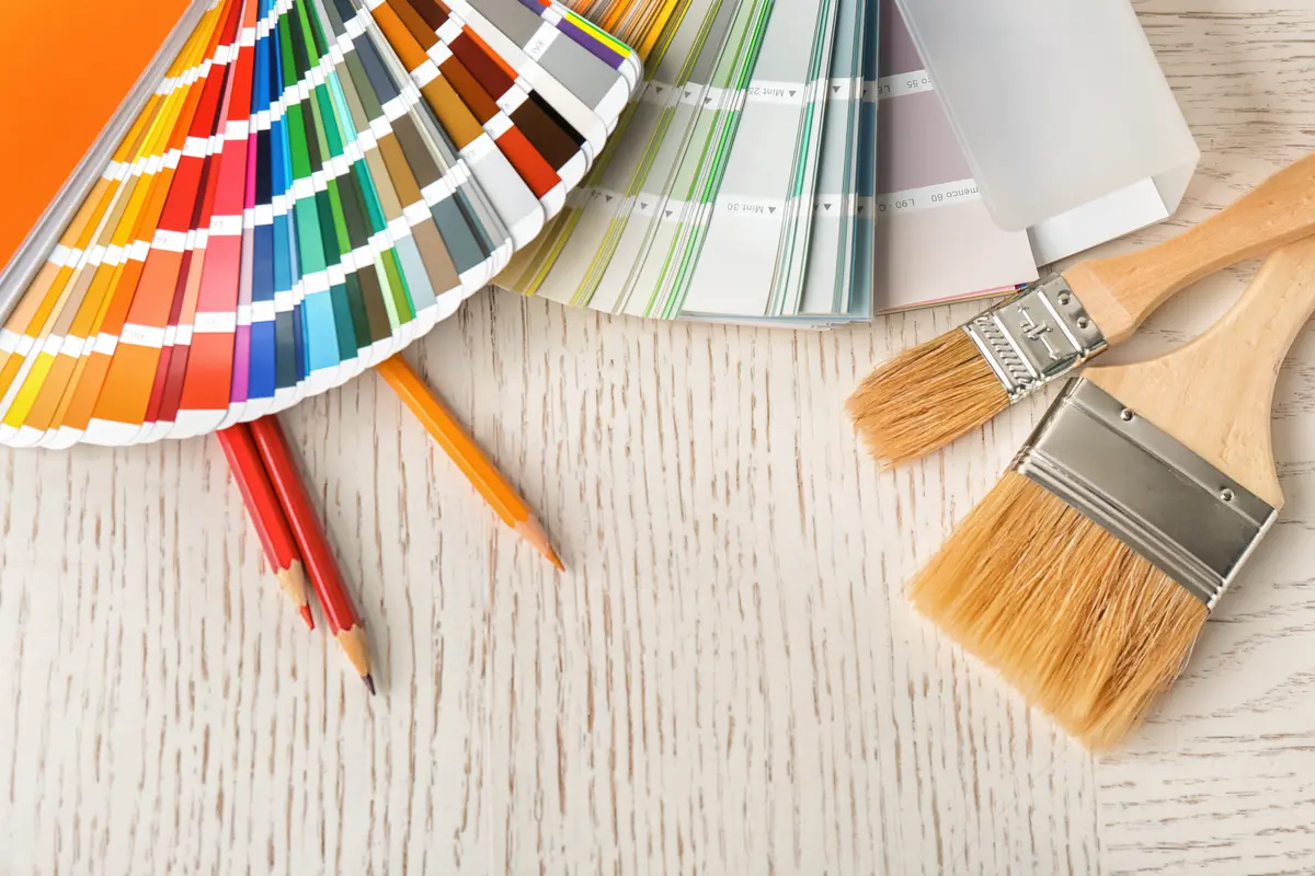Color swatch fan and paint brushes arranged on a table