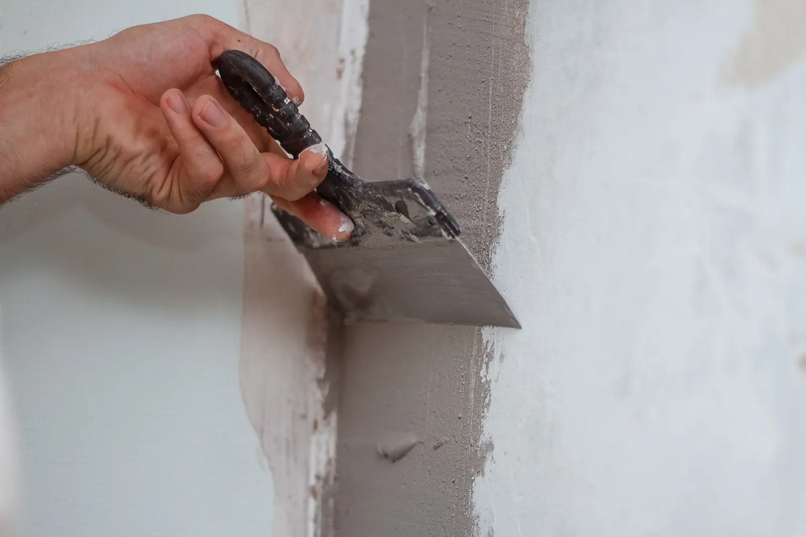 Trowel smoothing a protective coat on a masonry wall